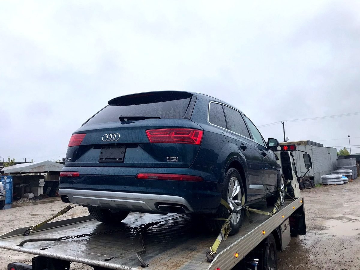 Audi Q7 strapped on the flatbed deck after being bought for cash